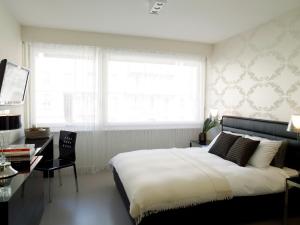 1 dormitorio con cama, escritorio y ventana en VISIONAPARTMENTS Rue Caroline - contactless check-in, en Lausana