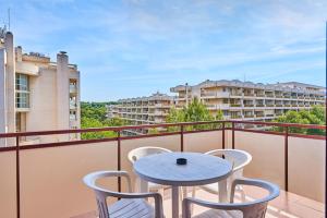 a balcony with a table and chairs and a building at Inter Apartments in Salou