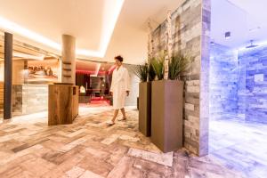 オルティゼーイにあるHotel Pineiの女性が建物のロビーを通り抜ける +37枚の写真