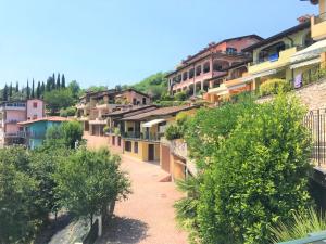 a row of houses on a hill with trees at Alice's Nest-Lake View House in Padenghe sul Garda