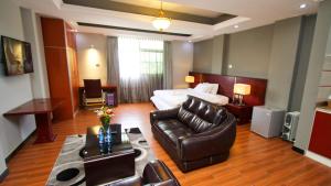 um quarto de hotel com uma cama e um sofá em Yinm Furnished Apartment em Addis Ababa
