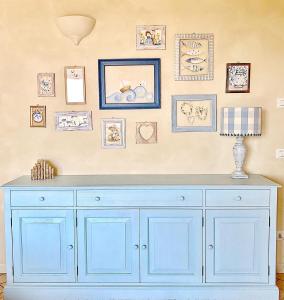 ein blauer Schrank in einem Zimmer mit Bildern an der Wand in der Unterkunft Alice's Nest-Lake View House in Padenghe sul Garda
