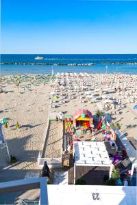 ベッラーリア・イジェア・マリーナにあるHotel Villa Sole Resortのたくさんの椅子とパラソルが備わるビーチ