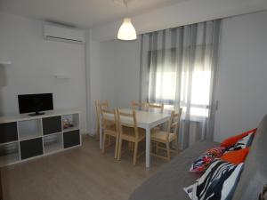 salon ze stołem, krzesłami i telewizorem w obiekcie APARTAMENTOS DAYMA w mieście Jarandilla de la Vera