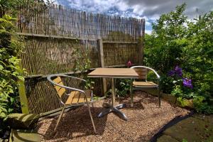 uma mesa e cadeiras num jardim com cerca em Wortley Cottage Guest House em Wortley