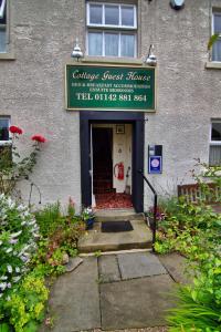 a building with a sign that reads cancer guest house at Wortley Cottage Guest House in Wortley