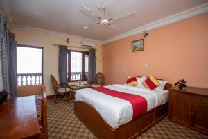 a hotel room with a large bed and a desk at Bandipur Mountain Resort in Bandīpur