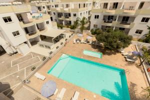 an overhead view of a swimming pool in front of buildings at Oceania Bay Village in Pyla