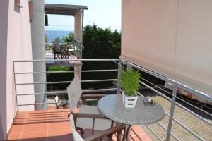 a table and chairs on a balcony with a view of the ocean at Agyra Studios in Vasilika
