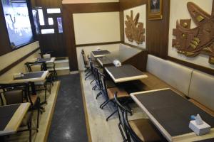 a row of tables and chairs in a restaurant at Hotel Arma Court - Near US Embassy, BKC in Mumbai