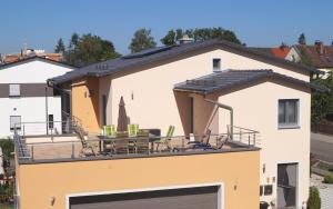 Casa con balcón con mesa y sillas en Ferienwohnung Weindler en Weiden