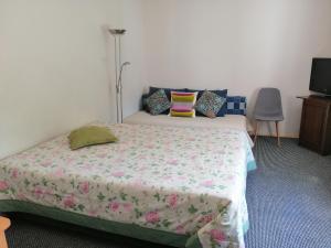 a bedroom with a bed with a flowered blanket at Liiva Guest Accommodation in Tartu