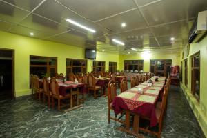 a restaurant with tables and chairs in a room at Bandipur Mountain Resort in Bandīpur