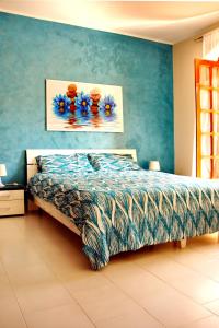 1 dormitorio con 1 cama con pared azul en Bed & Breakfast 21, en Gela