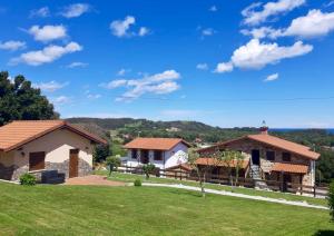 a house with a green lawn and two buildings at Apartamentos La Fragata in Isla