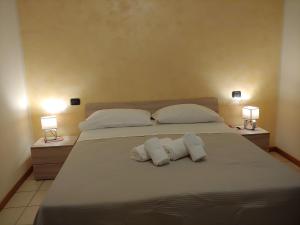ein Bett mit zwei Kissen und zwei Handtüchern darauf in der Unterkunft Tony Rooms & Apartments in Cavaion Veronese