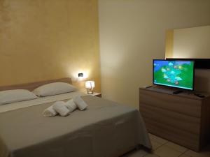 Schlafzimmer mit einem Bett und einem Flachbild-TV in der Unterkunft Tony Rooms & Apartments in Cavaion Veronese