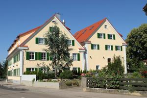 ein großes weißes Haus mit grünen Rollläden in der Unterkunft Landgasthof Krone in Senden