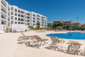ein Pool mit Chaiselongue und ein Resort in der Unterkunft Vista das Ondas 205 in Albufeira
