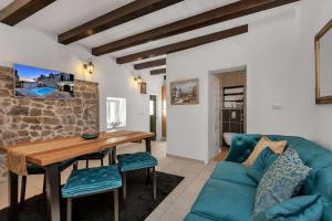 ein Wohnzimmer mit einem blauen Sofa und einem Holztisch in der Unterkunft Luxury Villa Topolina in Baška Voda