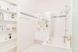 a white bathroom with a tub and a shower at Rainer Maria Rilke Suite in Vienna