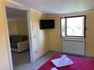 una sala de estar con televisión y un sofá en Casa Vacanze Nonna Suocera, en San Severino