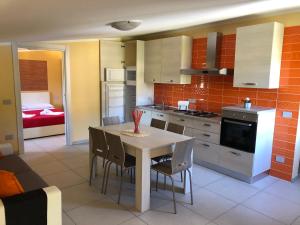 Una cocina con una mesa y sillas en una habitación. en Casa Vacanze Nonna Suocera, en San Severino