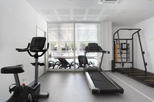 a gym with treadmills and ellipticals and a window at Résidence Prestige Odalys Les Canissons in Cavalaire-sur-Mer