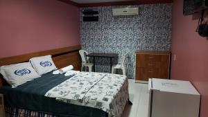 a bedroom with a bed and a table with chairs at Hotel Opção in Manaus