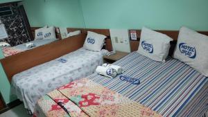 dos camas sentadas una al lado de la otra en una habitación en Hotel Opção, en Manaus