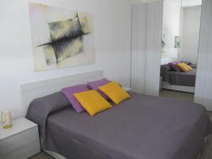 a bedroom with a bed with purple and yellow pillows at Station Home in Sesto San Giovanni