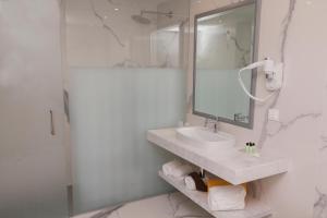 a bathroom with a sink and a shower with a mirror at Ocean Gardens in Funchal