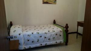 a small bed in a bedroom with a bedspread with flowers at Candida in Caracas