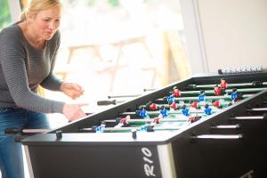 a woman standing next to a large pool table at Lupin Glamping Pod in Cheltenham