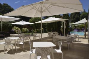 a group of tables and chairs with white umbrellas at L'Armateur in Moissac