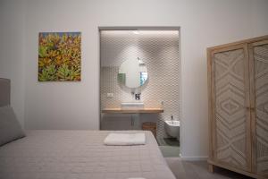 La salle de bains est pourvue d'un lit, d'un lavabo et d'un miroir. dans l'établissement Mondello Felix - appartamenti in villa a 600m dal mare, à Mondello