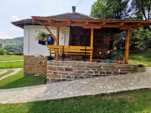 a pavilion with a wooden bench in a field at Etno kuća Radonjić - Family Retreat & Spa in Guča
