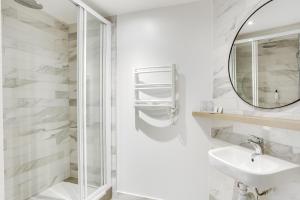 a white bathroom with a sink and a mirror at Hotel Courseine in Courbevoie +37 photos