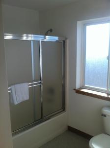 a bathroom with a shower and a toilet and a window at Crown Inn in Seattle
