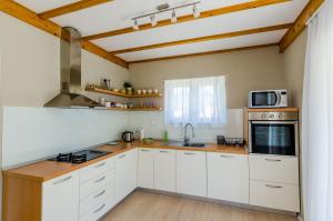 Apartment Three Olives في موكوسيكا: مطبخ مع دواليب بيضاء وميكرويف