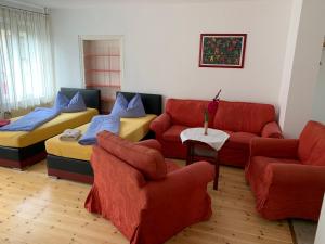 a living room with red couches and blue pillows at Pension Scheffler in Potsdam