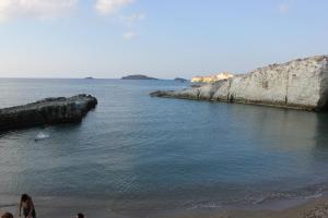 a group of people walking on the beach near the water at Galini in Agia Irini Milos