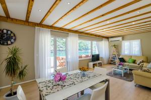 Apartment Three Olives في موكوسيكا: غرفة معيشة بسقف خشبي وطاولة وكراسي