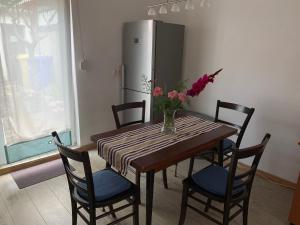 y cocina con mesa, sillas y nevera. en Pension Scheffler, en Potsdam