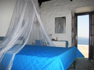 a bedroom with a bed with a mosquito net at Blue Horizon in Hydra