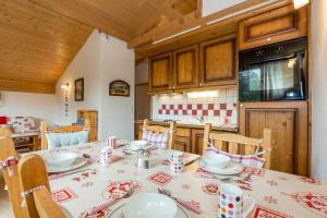 a dining room with a table and a kitchen at Apartment Le Kandahar in Les Houches