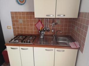 a kitchen with a sink and a stove at Case Nausica in Marina di Ragusa