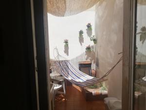 a hammock in a room with flowers on the wall at Case Nausica in Marina di Ragusa