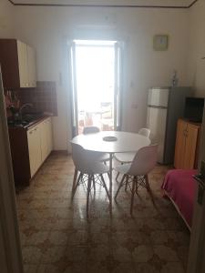 a kitchen with a table and chairs in a room at Case Nausica in Marina di Ragusa