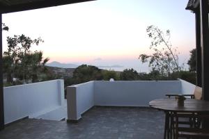a patio with a white fence and a table at Galini in Agia Irini Milos